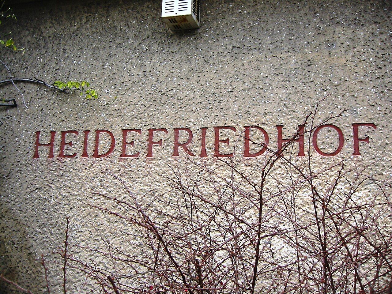 Eingangsbereich des Heidefriedhofs Berlin mit Namenszug an der Gebäudewand